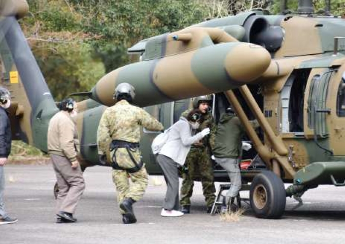 原子力総合防災訓練で自衛隊員の指示の下、ヘリコプターに乗り込む寄田地区の住民＝１５日午前１１時１０分ごろ、薩摩川内市