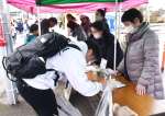 拉致問題の早期解決に向けて署名を呼びかける村岡育世さん（右）＝１６日、霧島市隼人