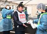放射性物質が付着していないか検査を受ける訓練参加者（中央）ら＝１６日、姶良市蒲生の県森林技術総合センター