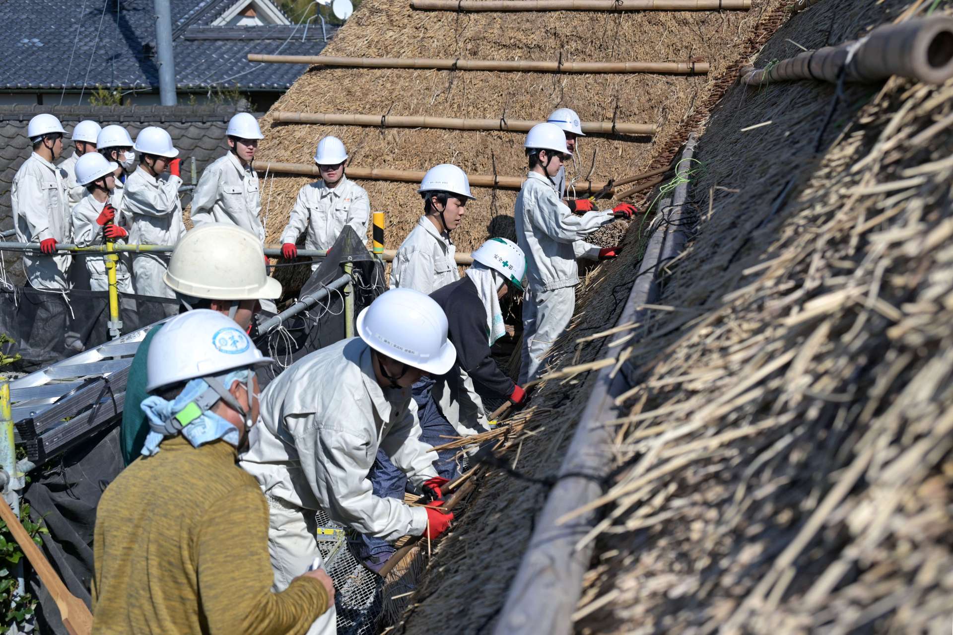 かやぶき屋根の補修を体験する薩南工業高校生＝南九州市知覧