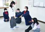 子どもたちと英語でフルーツバスケットをして遊ぶ大口明光学園高校２年のチーム「ライズ」＝伊佐市の大口元気こころ館