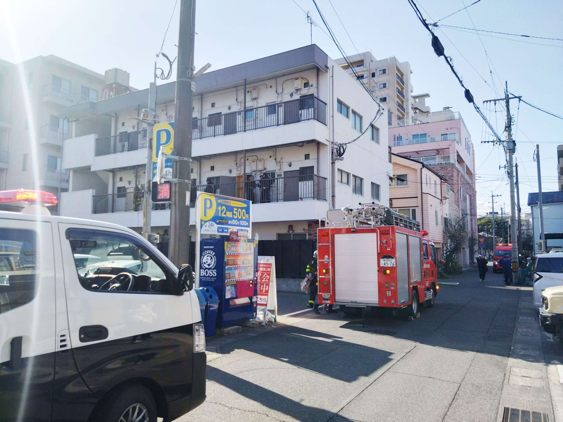 爆発事故があった部屋近くを調べる警察官と消防隊員＝１９日午前９時５５分ごろ、鹿児島市上荒田町