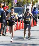 第９中継所、姶良の立元翔悟（右）からたすきを受ける中村高洋＝姶良市