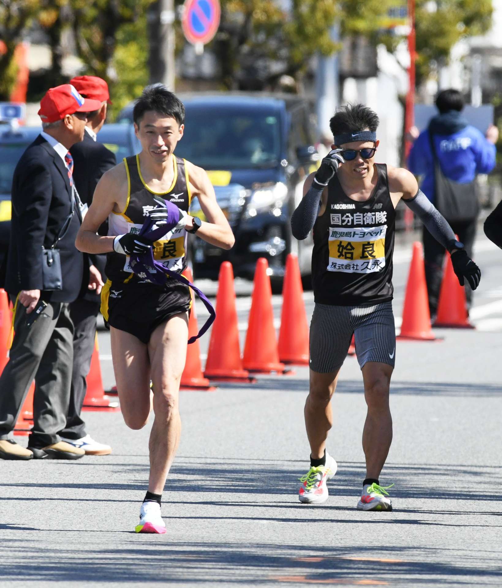 第９中継所、姶良の立元翔悟（右）からたすきを受ける中村高洋＝姶良市