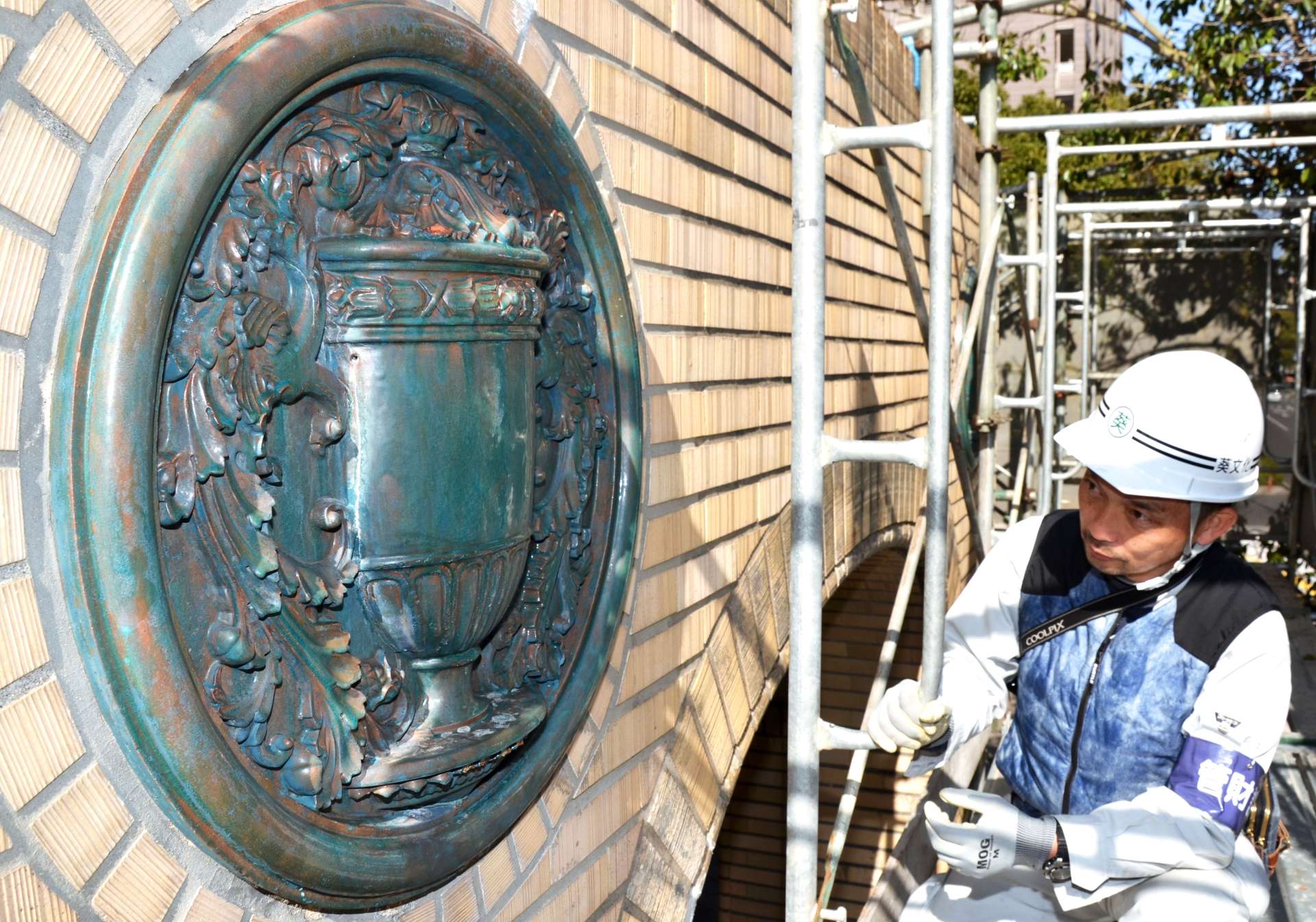 青色のペンキがはがされ、緑がかったうわぐすりが現れた薩摩焼レリーフ＝鹿児島市役所本館正面玄関