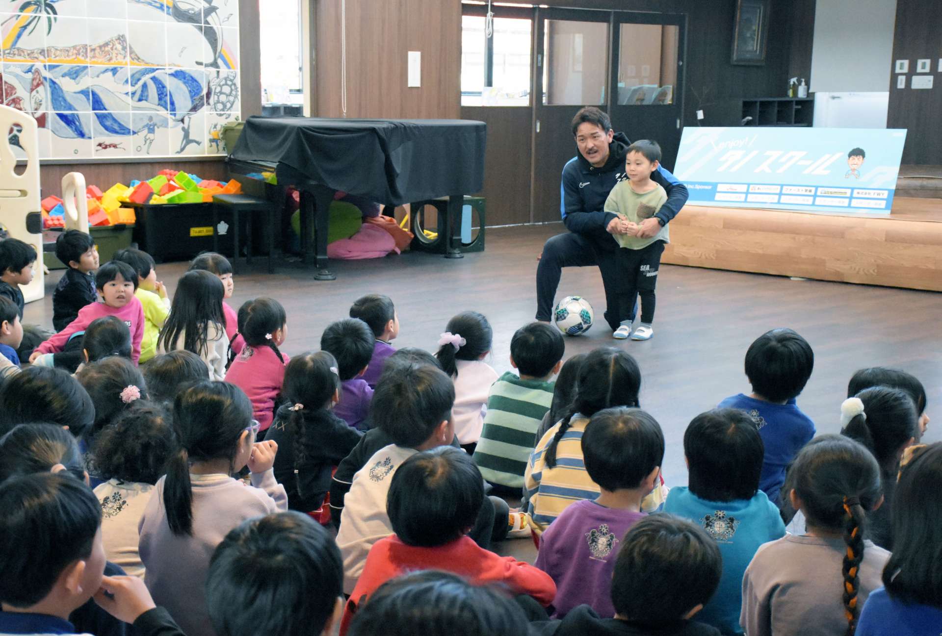 園児にシュートのコツを指導する田上裕さん＝１９日、指宿市のコスモス幼稚園