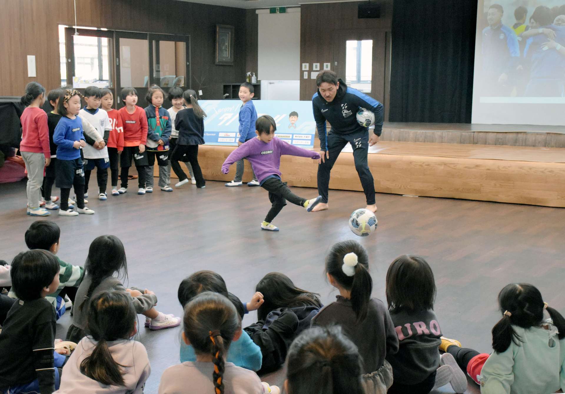 園児にシュートのコツを指導する田上裕さん＝１９日、指宿市のコスモス幼稚園