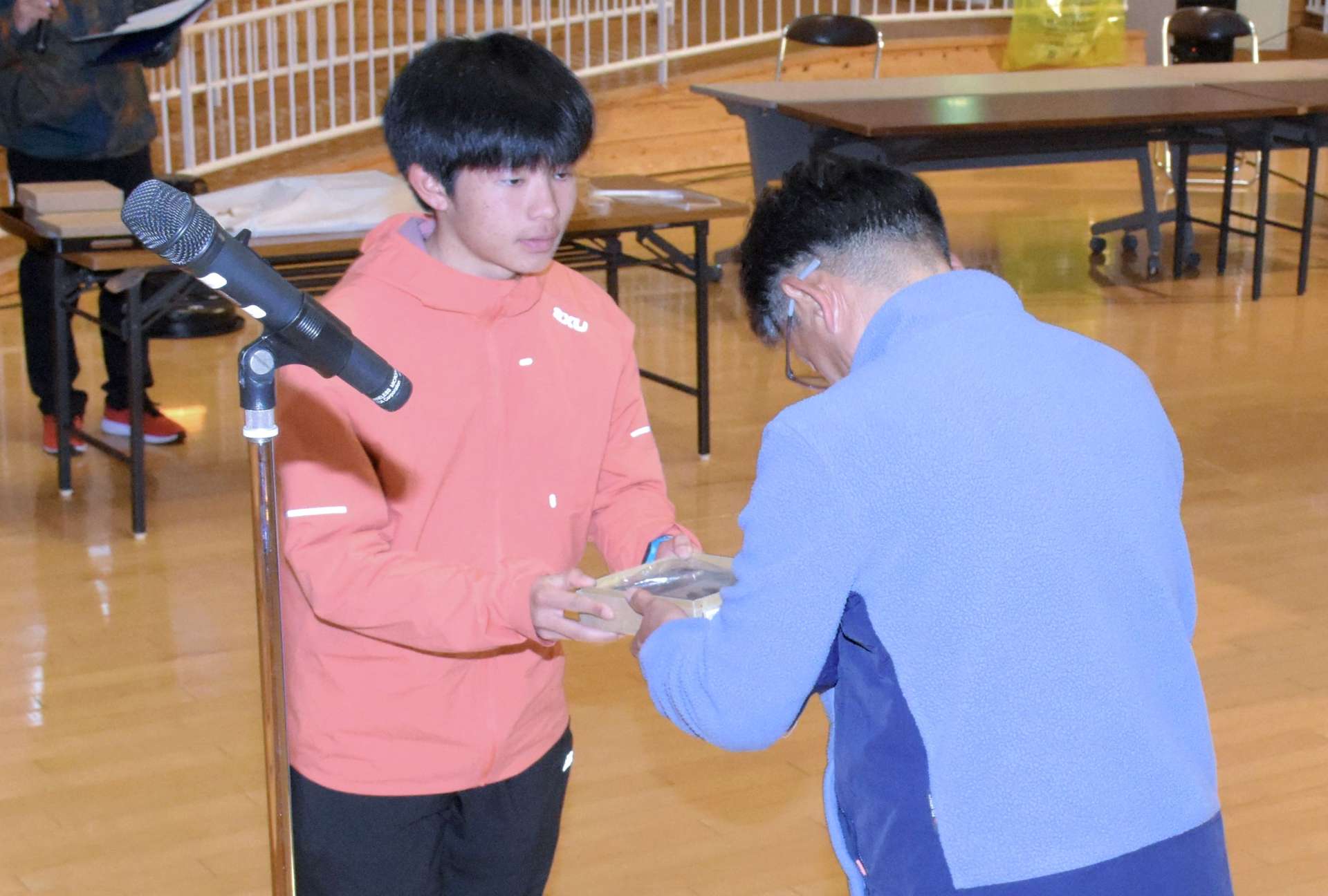 垣内英人監督からチームの敢闘賞を受け取る中道佳大選手＝１９日、指宿市のふれあいプラザなのはな館