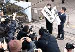 「不当判決」と書かれた紙を掲げる原告団＝２１日午後、鹿児島市の鹿児島地方裁判所
