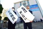 「不当判決」の紙を掲げる森永明子原告団長（左）ら＝２１日午後３時９分、鹿児島市山下町