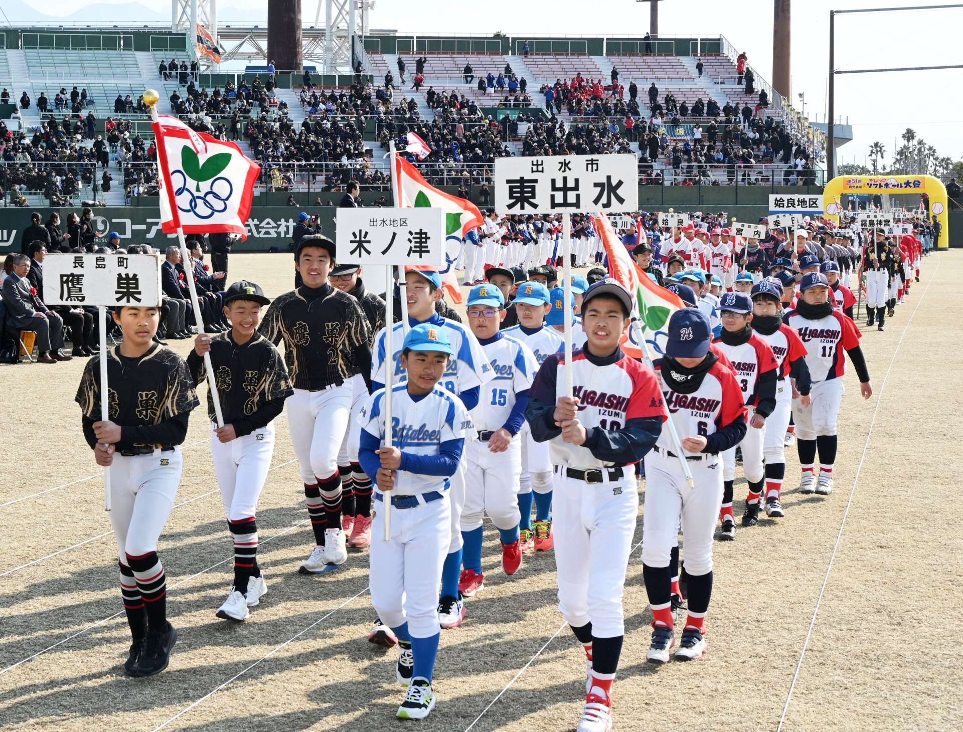 元気よく入場行進する選手たち＝鹿児島市の平和リース球場