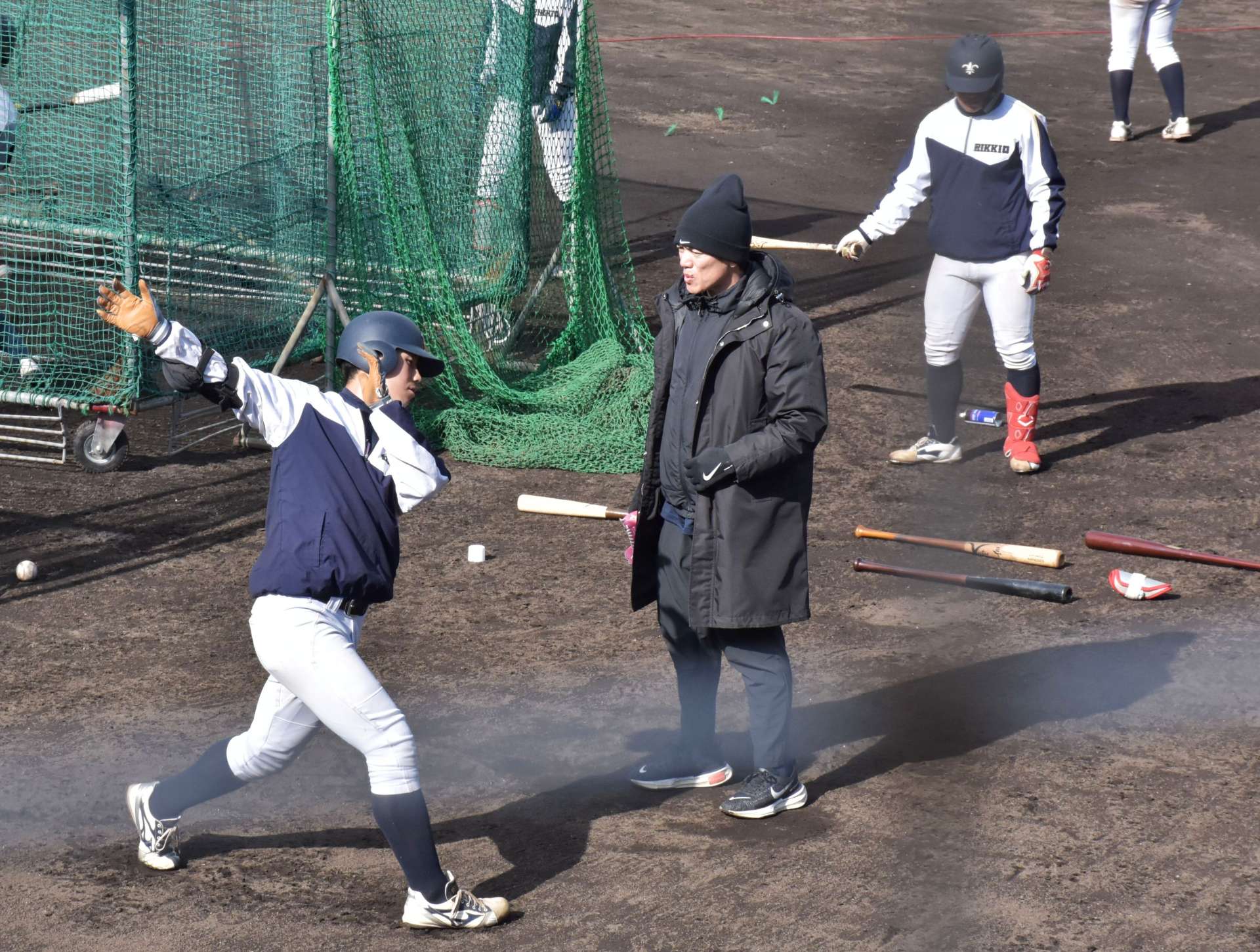 立教大野球部のキャンプで、手本を示してアドバイスする松井稼頭央さん（中央）＝阿久根市野球場