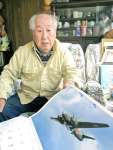 戦闘機の載ったカレンダーを見ながら、当時を振り返る宮後正行さん＝日置市吹上