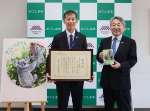 鹿児島市公園公社を代表してコアラの本を贈呈した福守朗平川動物公園長（左）＝【預Ｓ注意】１８日、【預Ｅ注意】市教育総合センター