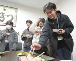 グローバル・オーシャン・ワークスで養殖されたブリを試食する学生＝垂水市牛根麓