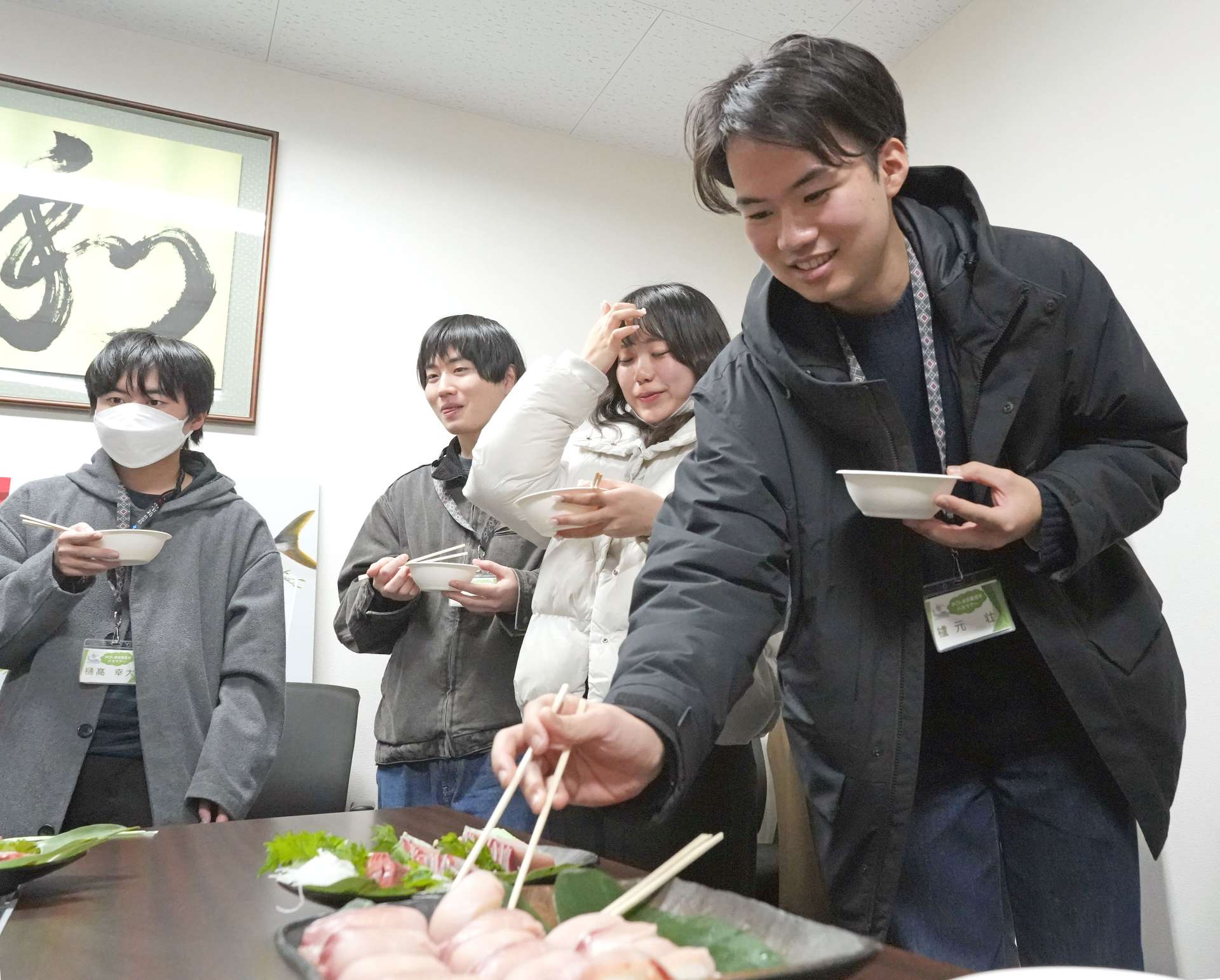 グローバル・オーシャン・ワークスで養殖されたブリを試食する学生＝垂水市牛根麓