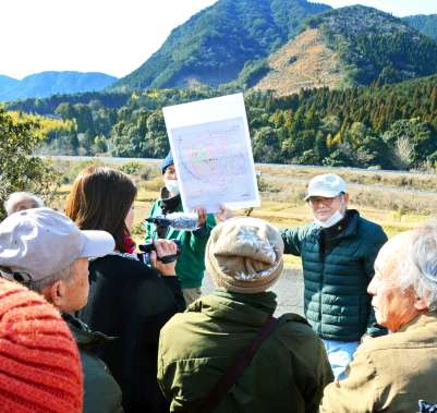 〈関連〉中岳（正面奥）を見ながら弾薬庫整備の経緯を聞く参加者＝２３日、さつま町永野