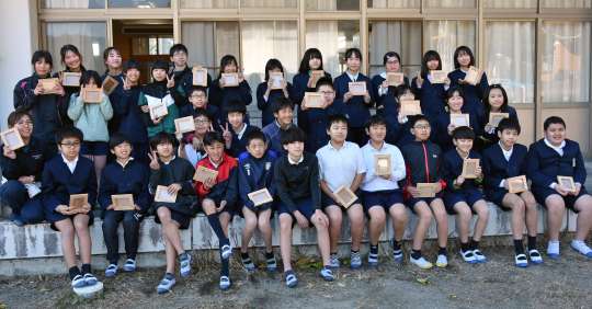 〈関連〉卒業記念に作った写真立てを手にする児童＝南大隅町の神山小学校