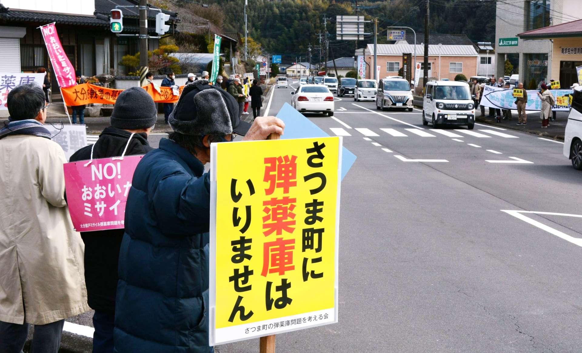 中岳が望める交差点で弾薬庫反対を訴える参加者＝２３日、さつま町求名