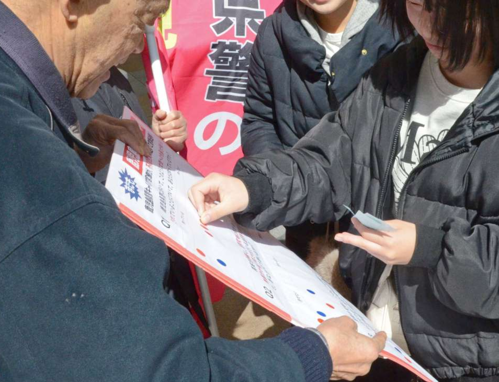鹿児島県警の不祥事に関するアンケートに答える通行人（右）＝２４日、鹿児島市の天文館