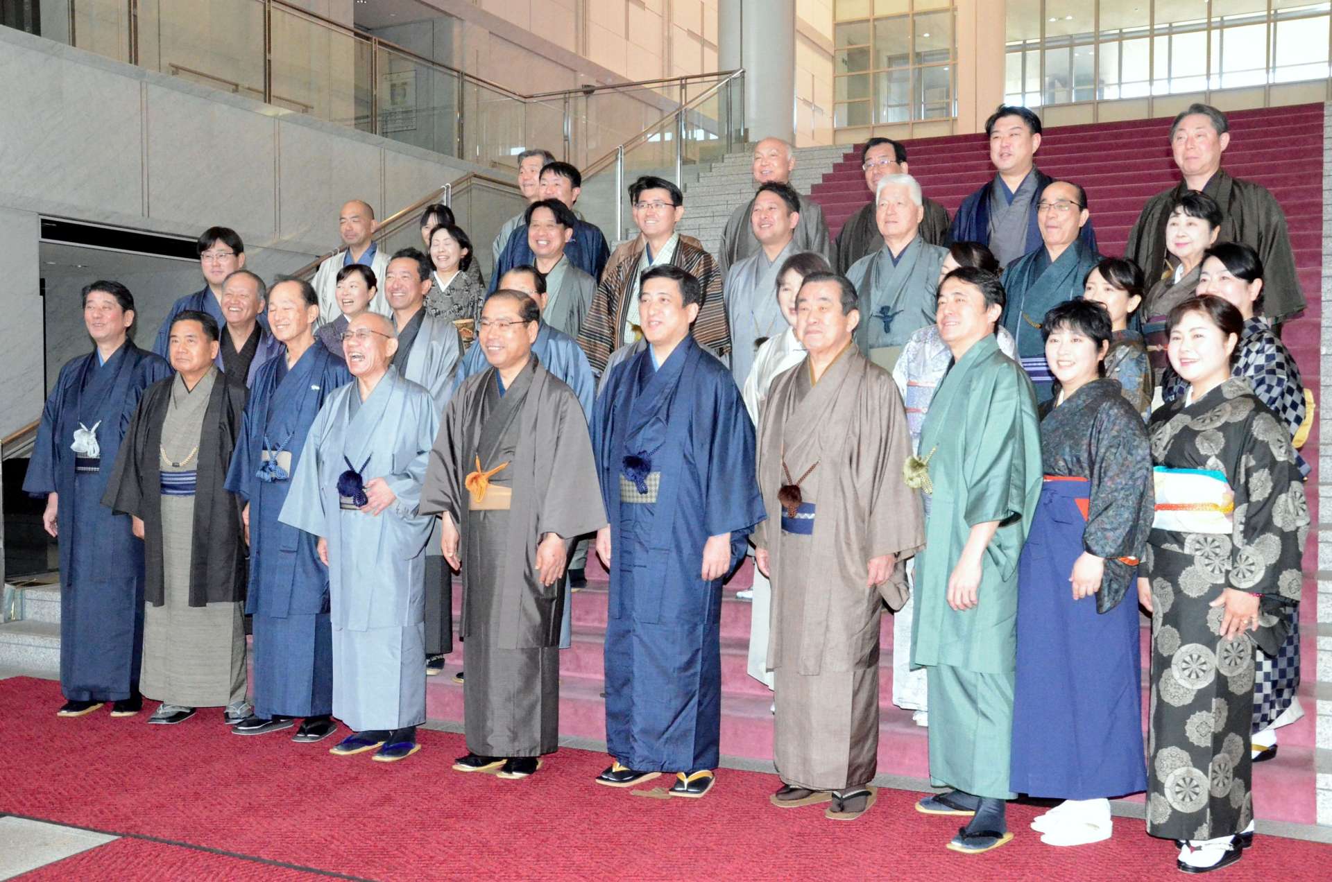 本会議の合間に大島紬姿で記念撮影に臨む塩田康一知事（前列右から５人目）や県議ら＝２５日、県議会