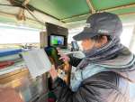 タブレットで海況予測を確認する漁業者＝指宿市（鹿児島県水産技術開発センター提供）