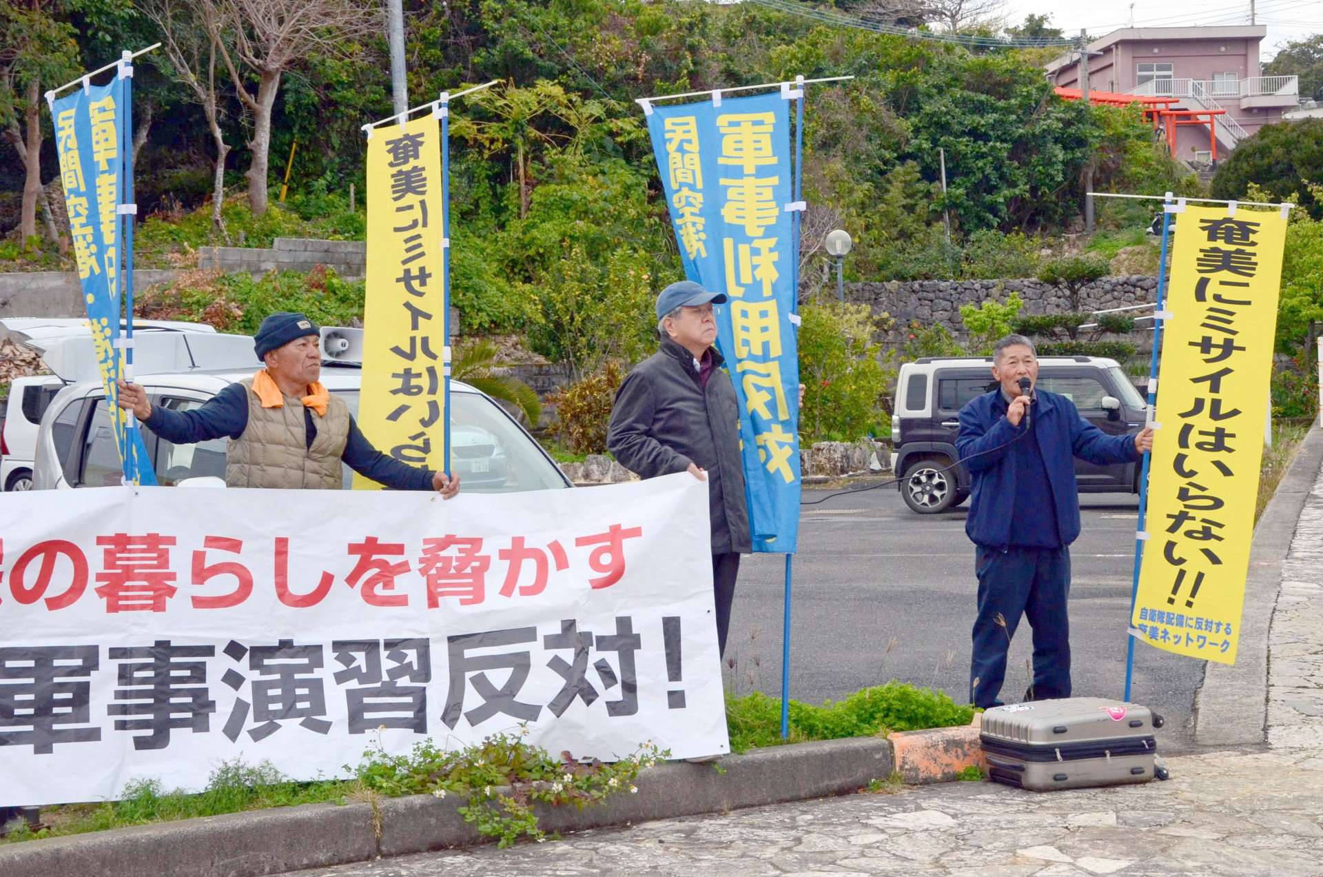 訓練の中止を求め抗議する市民団体のメンバーら＝２６日、知名町知名
