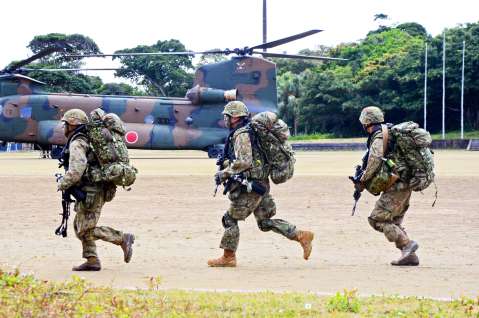ヘリコプターから降り、戦闘訓練に向かう水陸機動団の隊員＝２７日午後２時、知名町の大山総合グラウンド