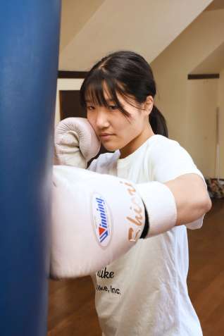 （別カット）自宅のトレーニングルームでサンドバッグに向かう四元志桜里さん＝霧島市福山町福山