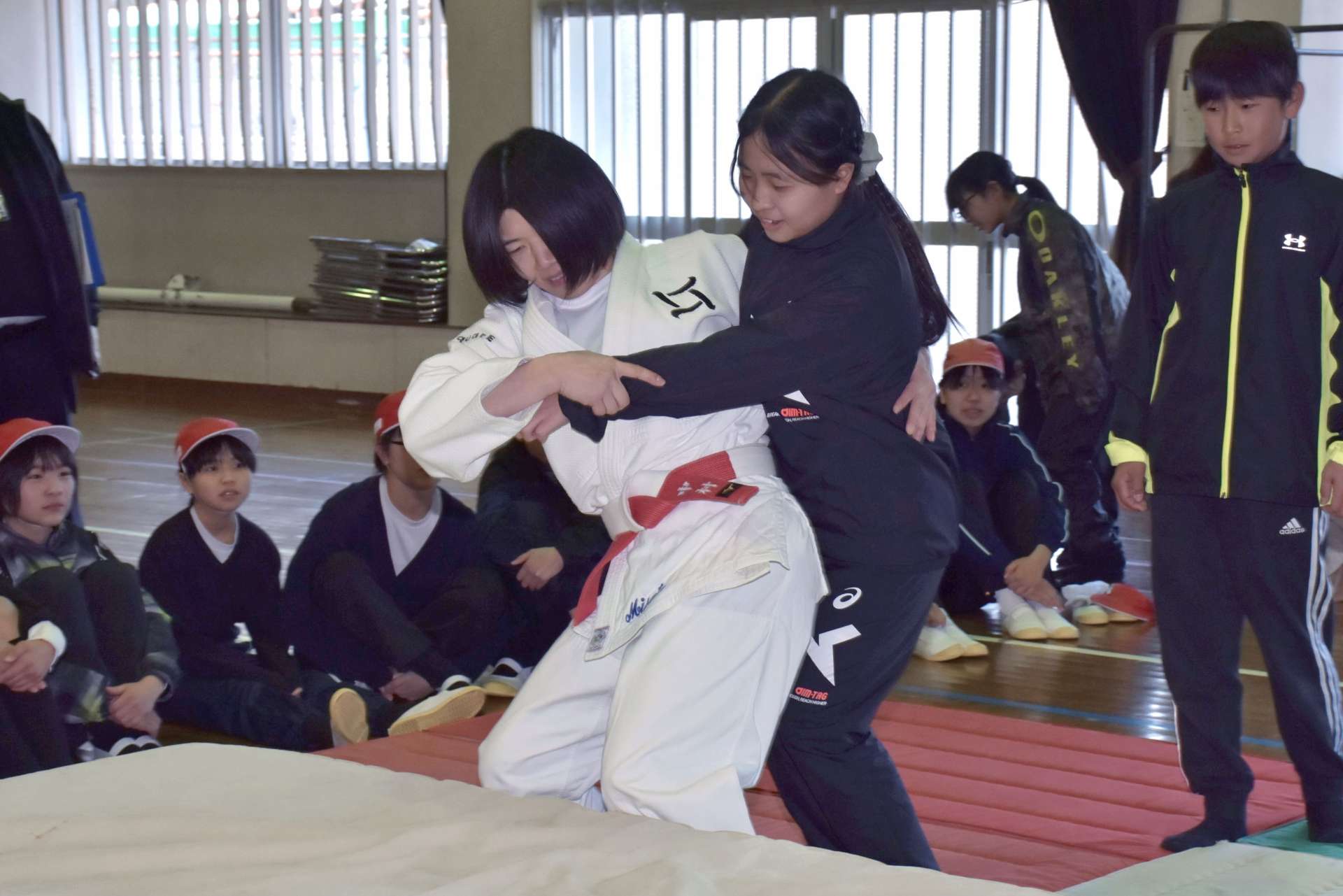 中村美里さんに柔道の投げ技をかけてもらう児童ら＝長島町の川床小学校
