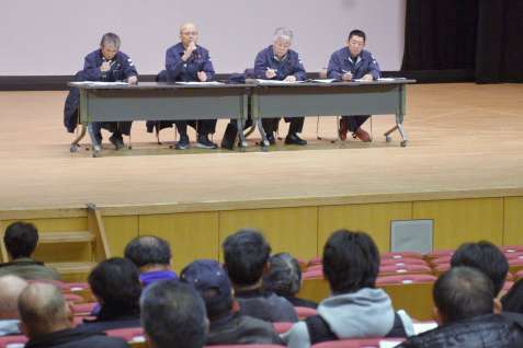 サトウキビ農家に状況を説明する新光糖業の担当者＝２月２６日午後７時すぎ、中種子町野間