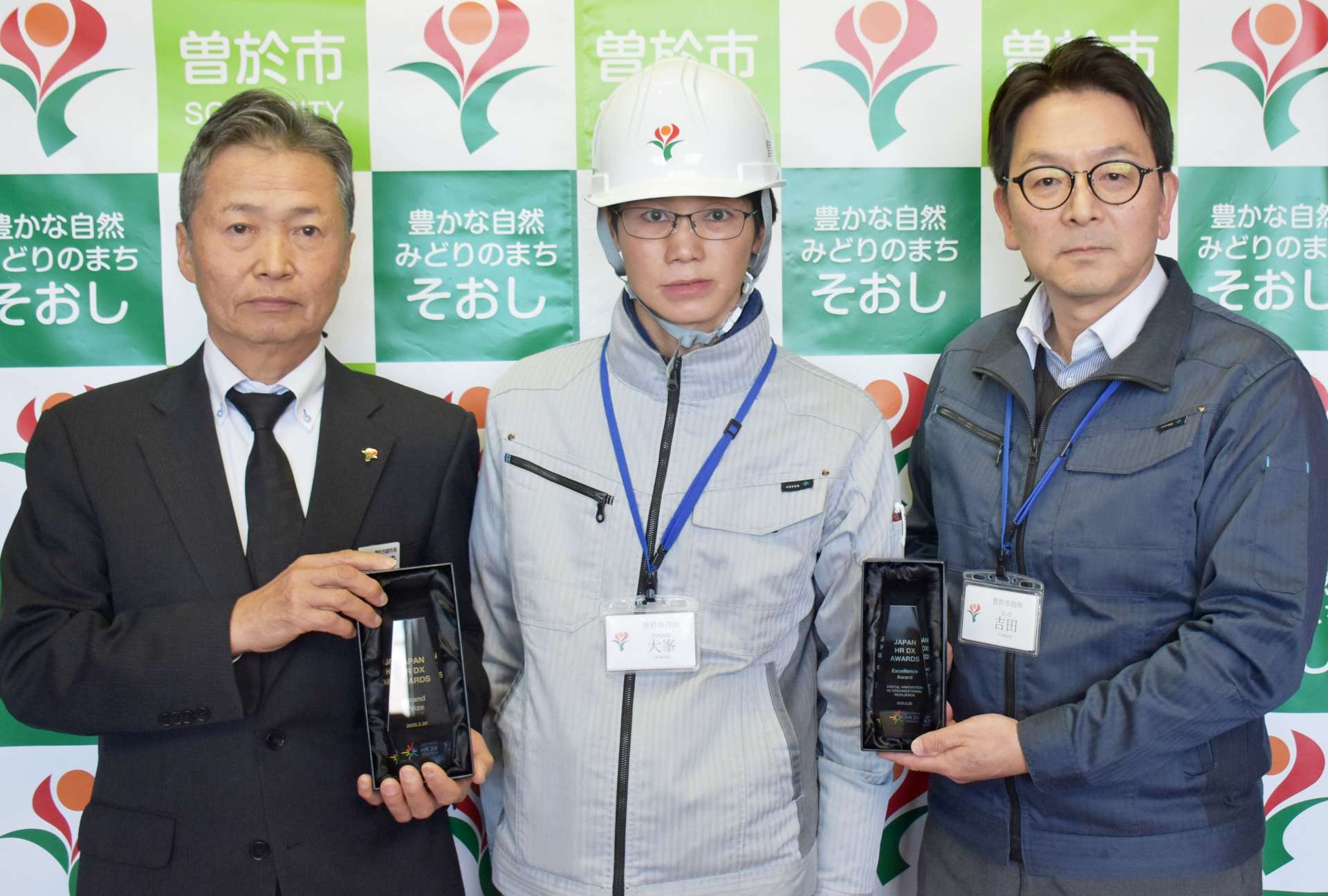 曽於市の取り組みで開発を担当した水道課の大峯直樹さん（中央）＝同市役所