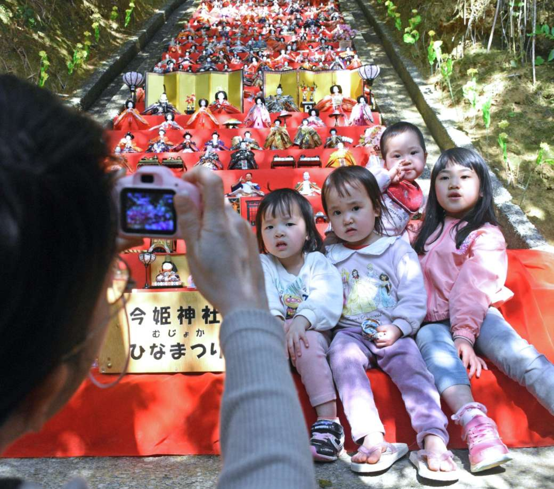 ４３段のひな飾りの前で写真を撮る親子＝１日、中種子町増田