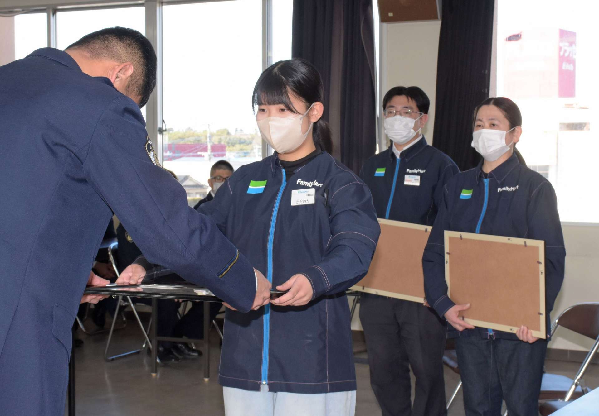感謝状を受け取るファミリーマート指宿なのはな館前店の従業員＝指宿市の指宿警察署