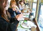 鹿児島県産の茶葉を使ったスイーツと紅茶を楽しむ乗客＝１日、鹿児島市