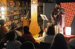 夜の図書館で歌を披露するＺａｉさん＝指宿市の指宿図書館