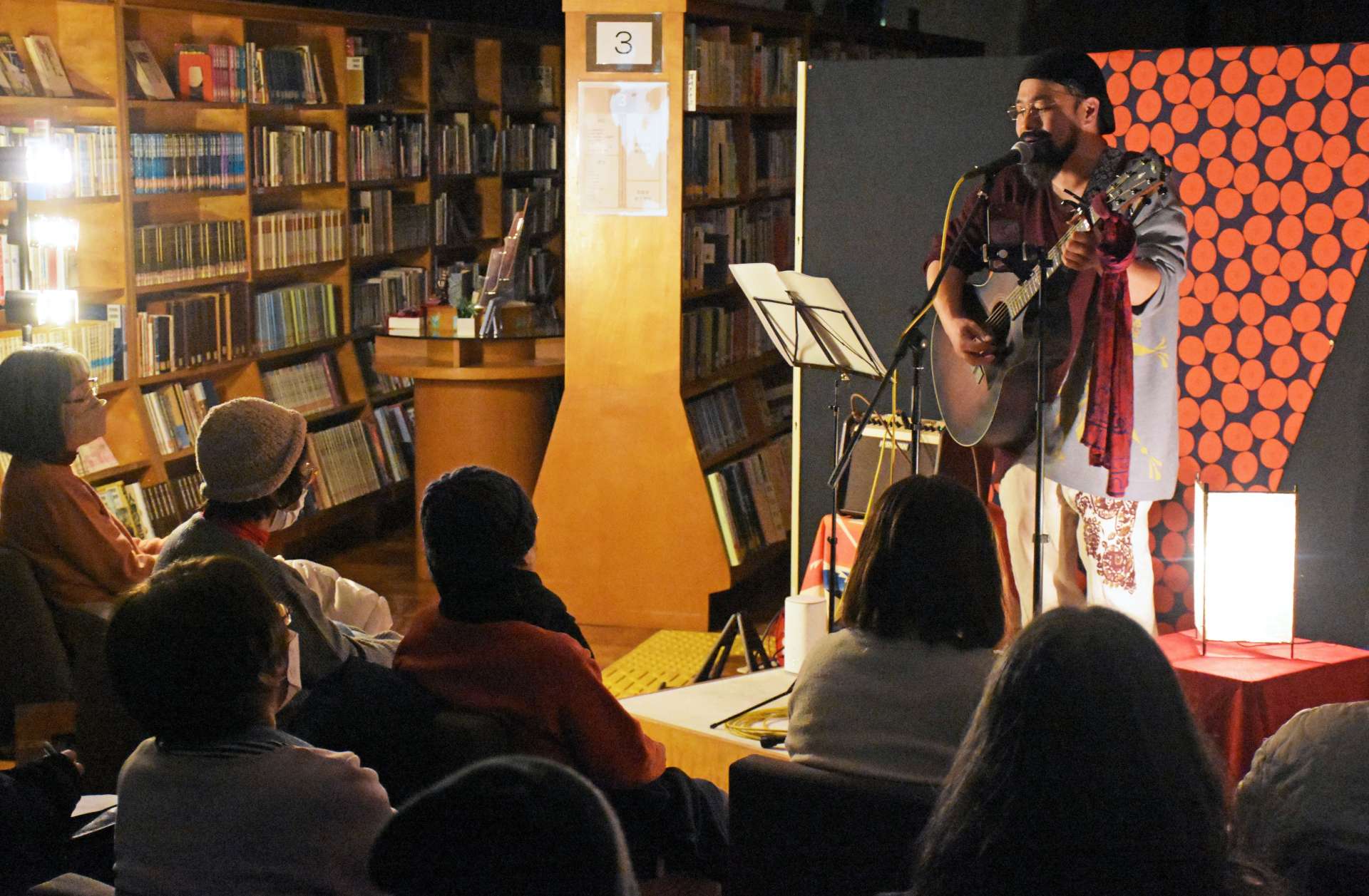夜の図書館で歌を披露するＺａｉさん＝指宿市の指宿図書館