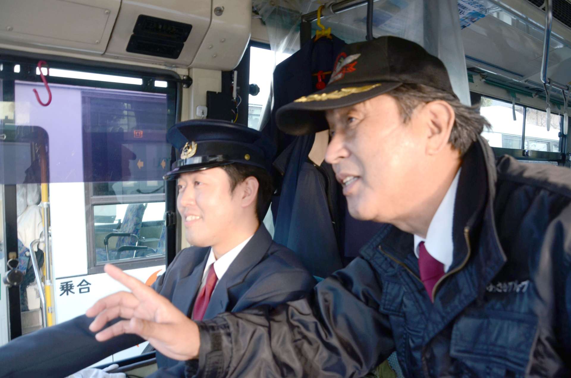 父の春田正三さんから技術と誇りを受け継ぐ航平さん（左）＝２４年１１月、鹿児島市浜町の鹿児島交通鹿児島営業所
