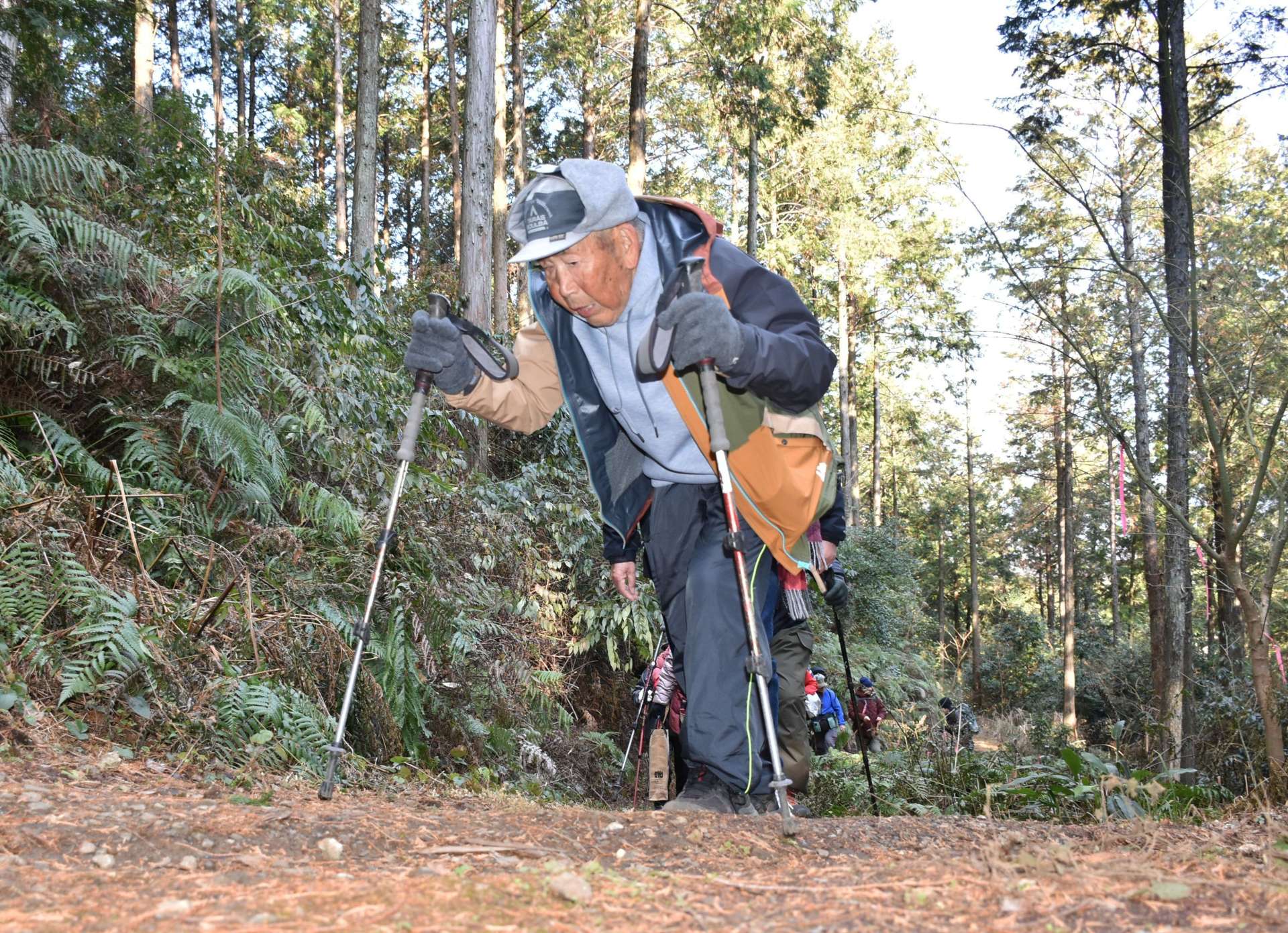 しっかりとした足取りで１００歳の誕生日会場である標高４０４メートルの鳥神岡山頂を目指す大久保利成さん＝伊佐市大口鳥巣