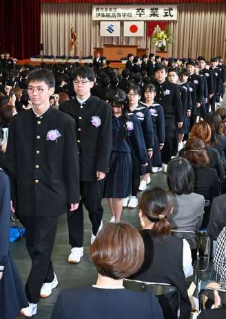 在校生や保護者らに見送られ退場する卒業生＝３日、日置市の伊集院高校