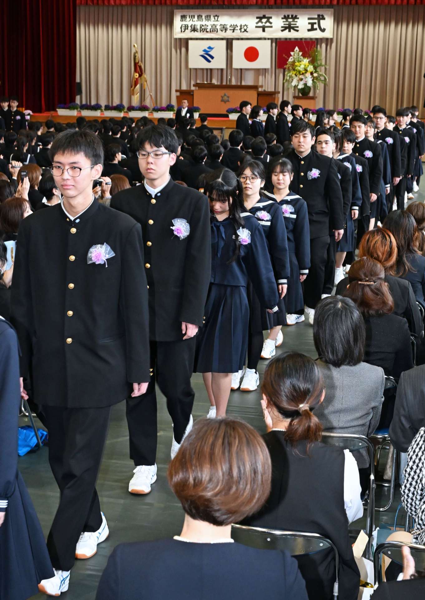 在校生や保護者らに見送られ退場する卒業生＝３日、日置市の伊集院高校