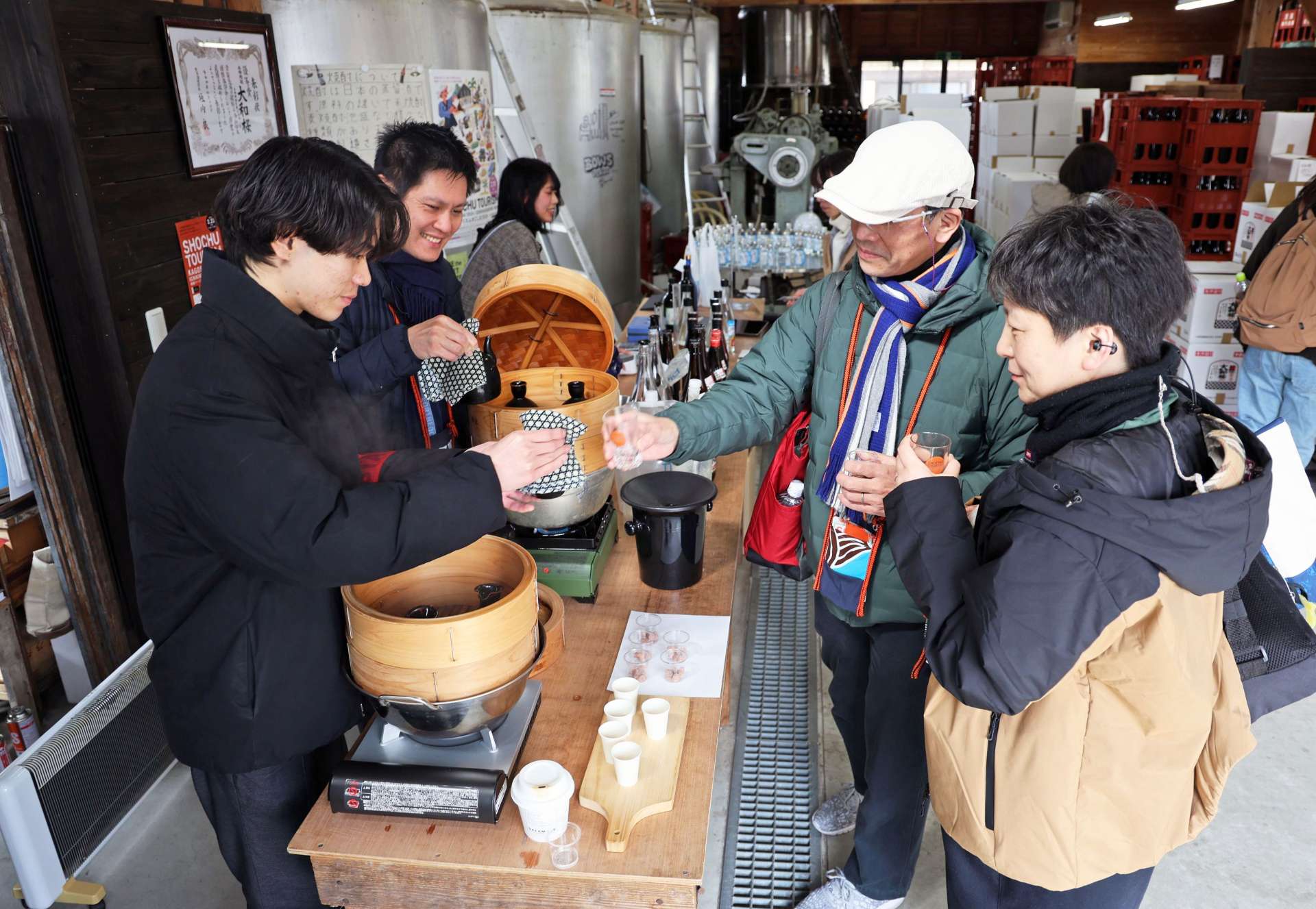 水で割って蒸した焼酎を試飲する参加者＝いちき串木野市の大和桜酒造