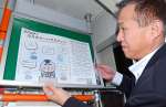 車内にポスターを張る阿多俊二鹿児島営業所副所長＝２月、鹿児島市小野町の南国交通鹿児島営業所