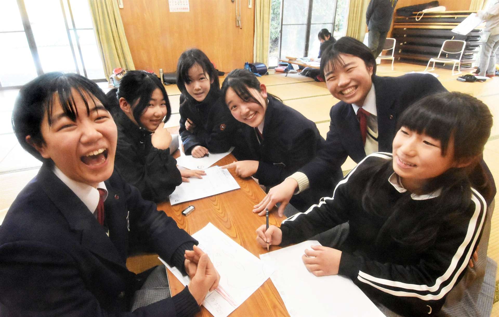 放課後教室で川畑小児童の宿題を手伝う加世田高校生＝南さつま市の川畑里公民館