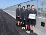 橋名板を書いた志布志高校書道部の４人＝志布志市の町原大橋