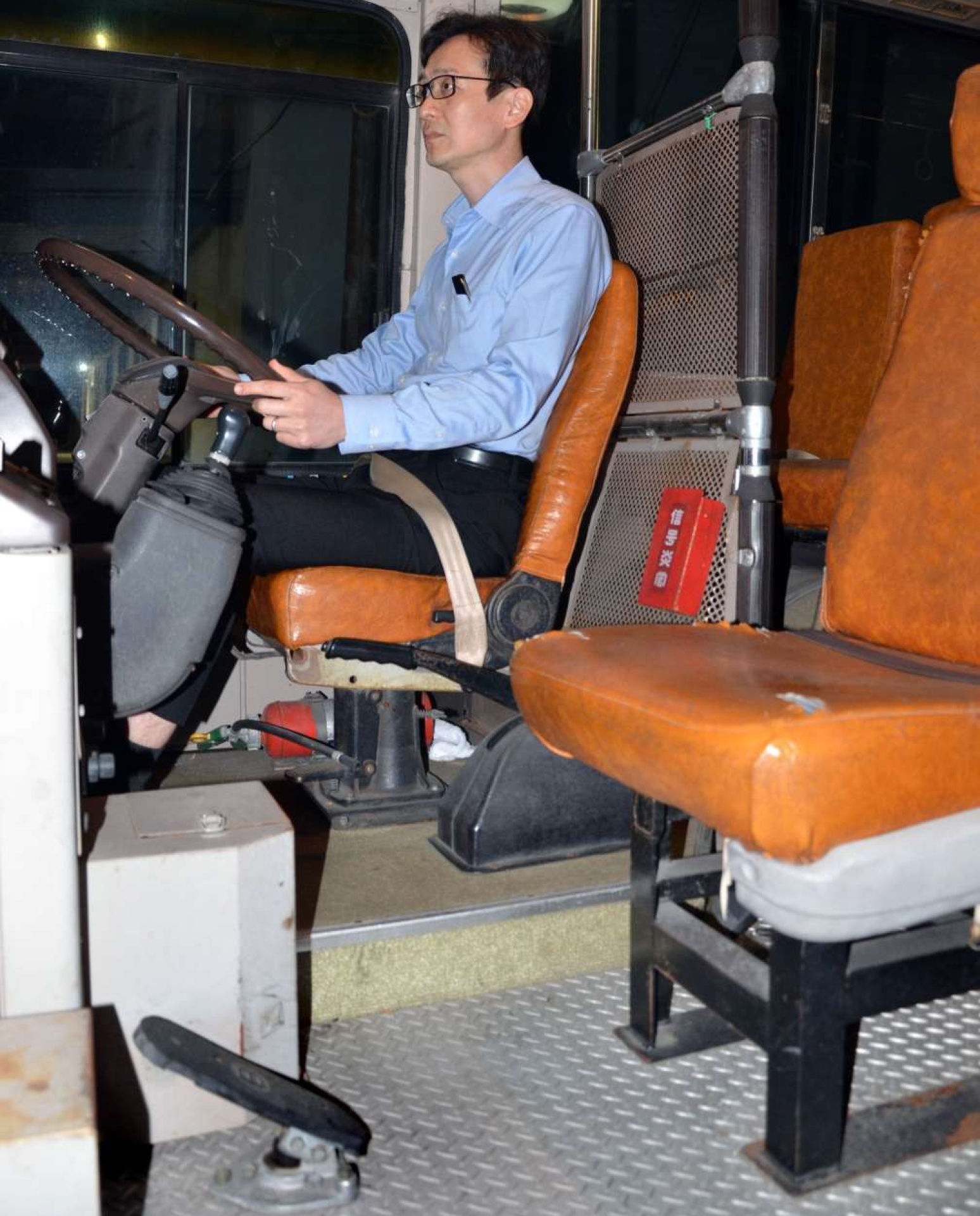 大型２種免許の教習で使用するバスの車内。中央の通路に指導員用の座席と非常ブレーキが付いている＝鹿児島市田上４丁目の田上自動車学校