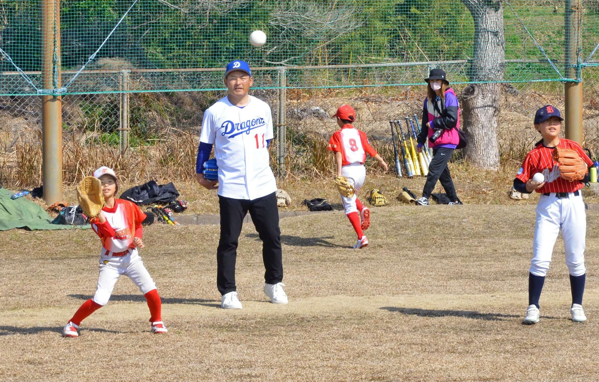 子どもたちのキャッチボールを見つめる川上憲伸さん＝日置市日吉