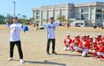 子どもたちに、投球のコツを指導する川上憲伸さん（左）ら＝日置市日吉