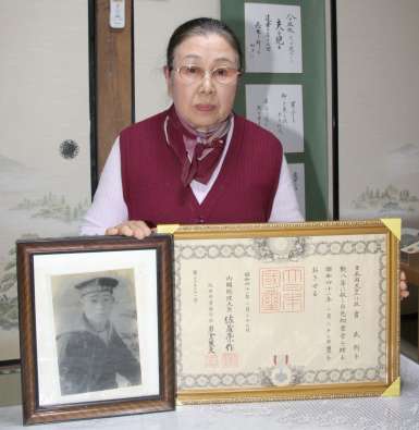 義兄の遺影を手にする清田和子さん＝天城町浅間