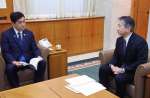 塩田康一知事（左）に提言書の内容を伝える津曲貞利座長＝７日、県庁